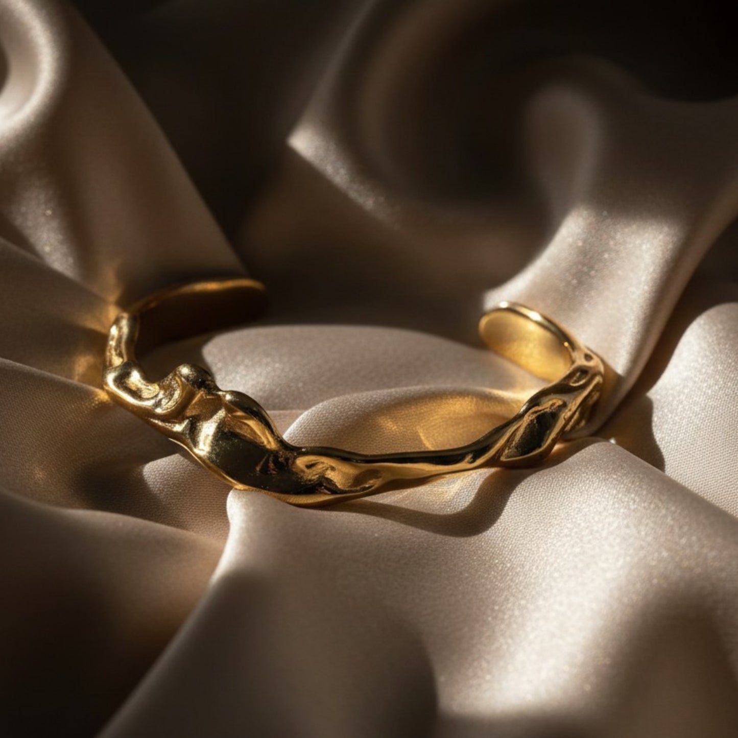 Gold plated cuff on silk background