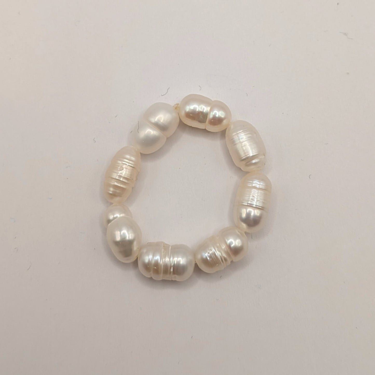 Pearl ring on a light gray background