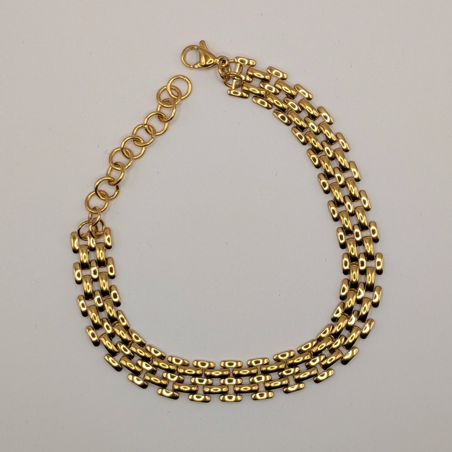 Gold chain bracelet on white background