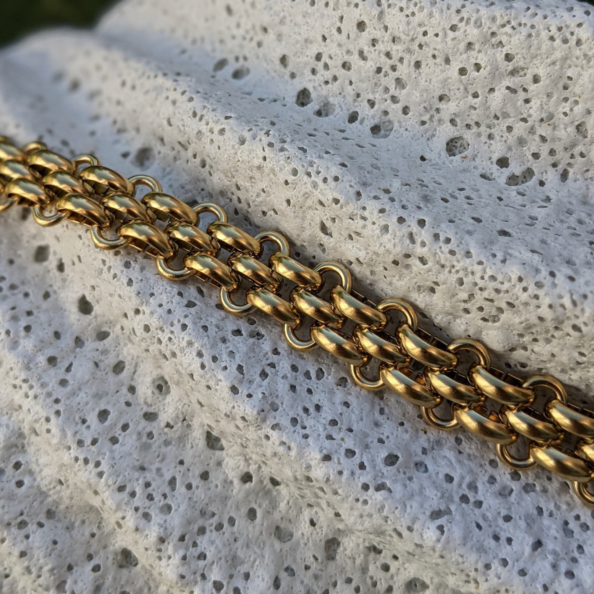 18k gold plated chain on a textured stone surface