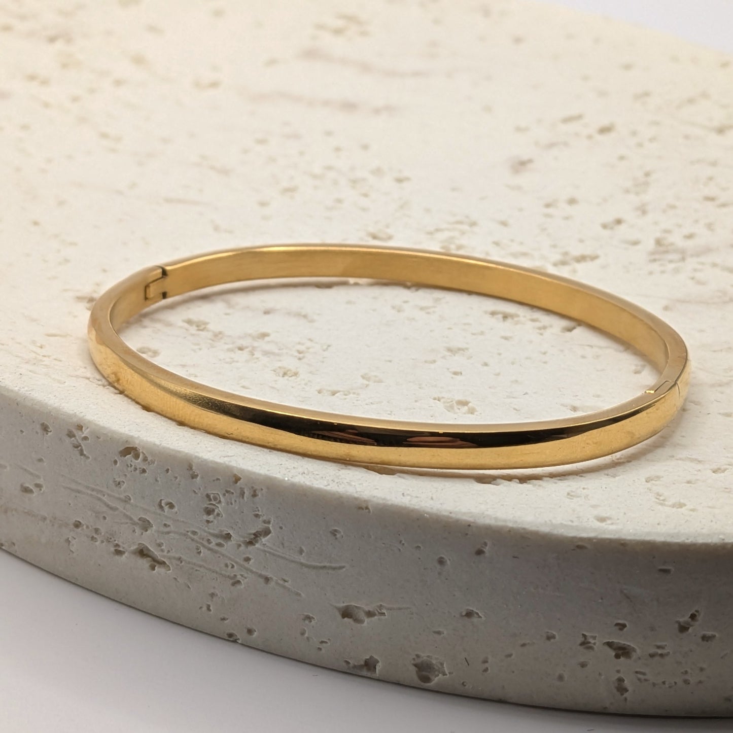 Gold plated bracelet on a textured stone surface