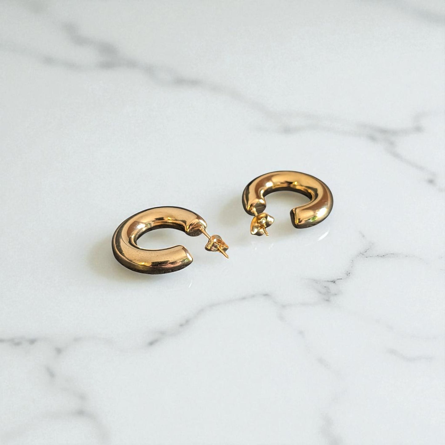 18K Gold plated earrings on marble background
