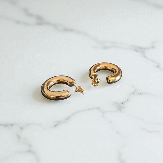 18K Gold plated earrings on marble background