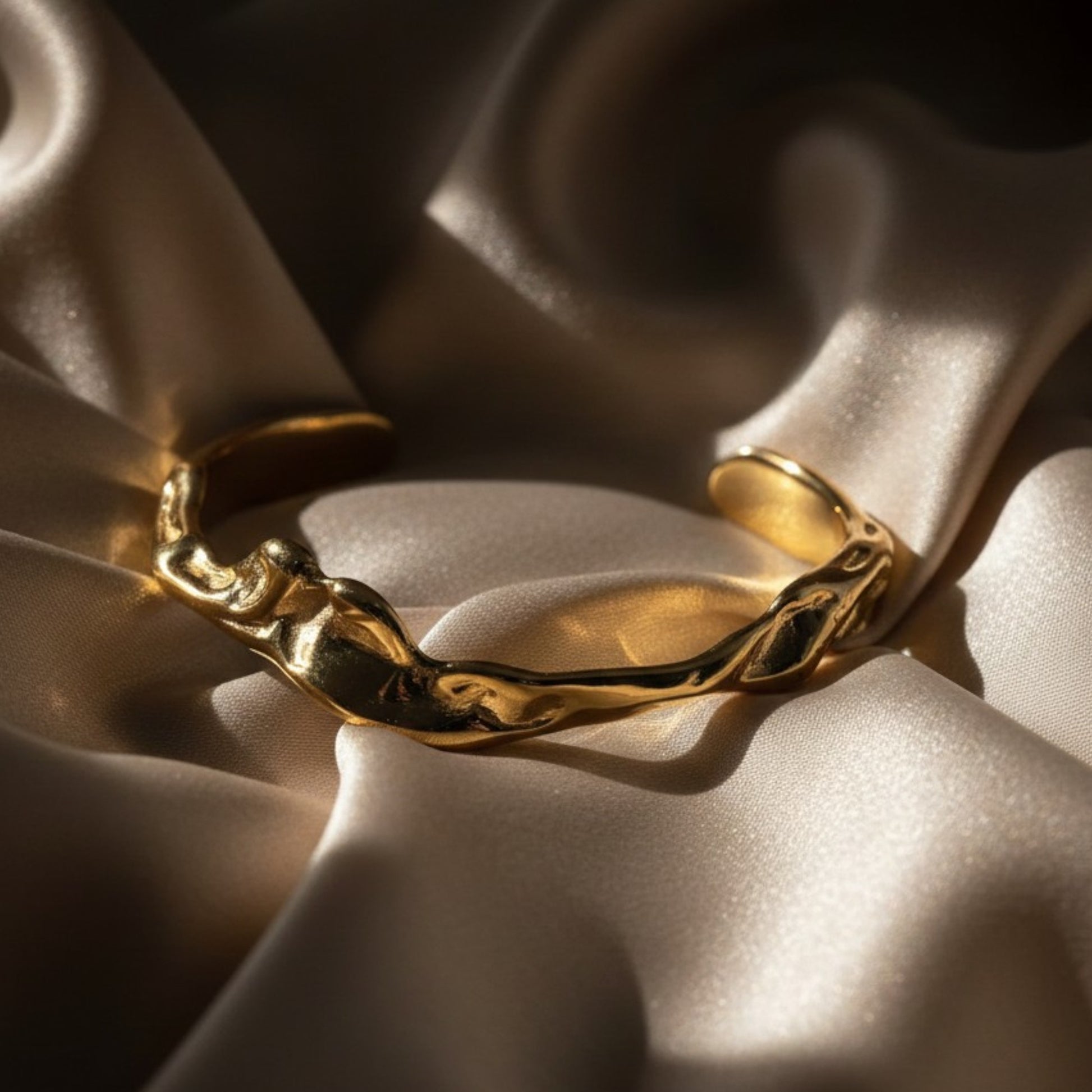 Gold plated cuff on silk background