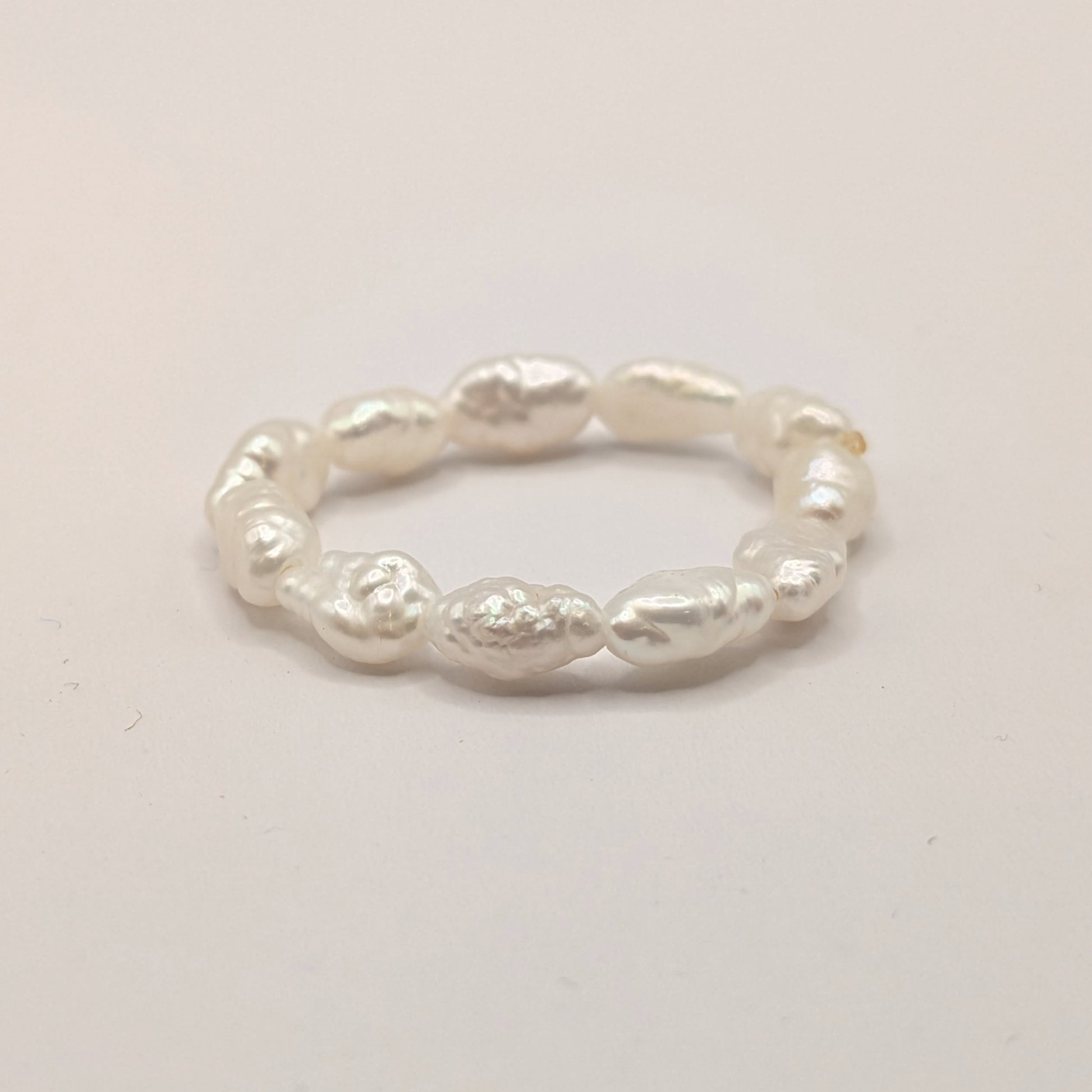 Silver ring with textured design on a light gray background