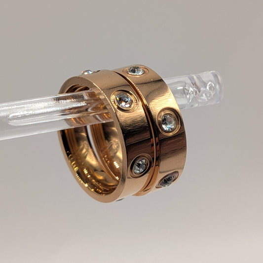 Rose gold ring with embedded diamonds on a clear background