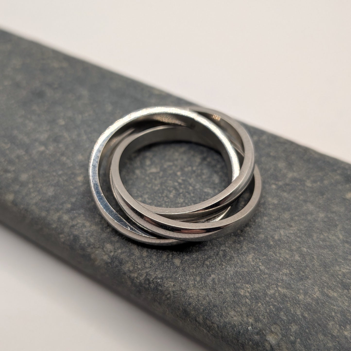 Stack of silver rings on a textured gray surface
