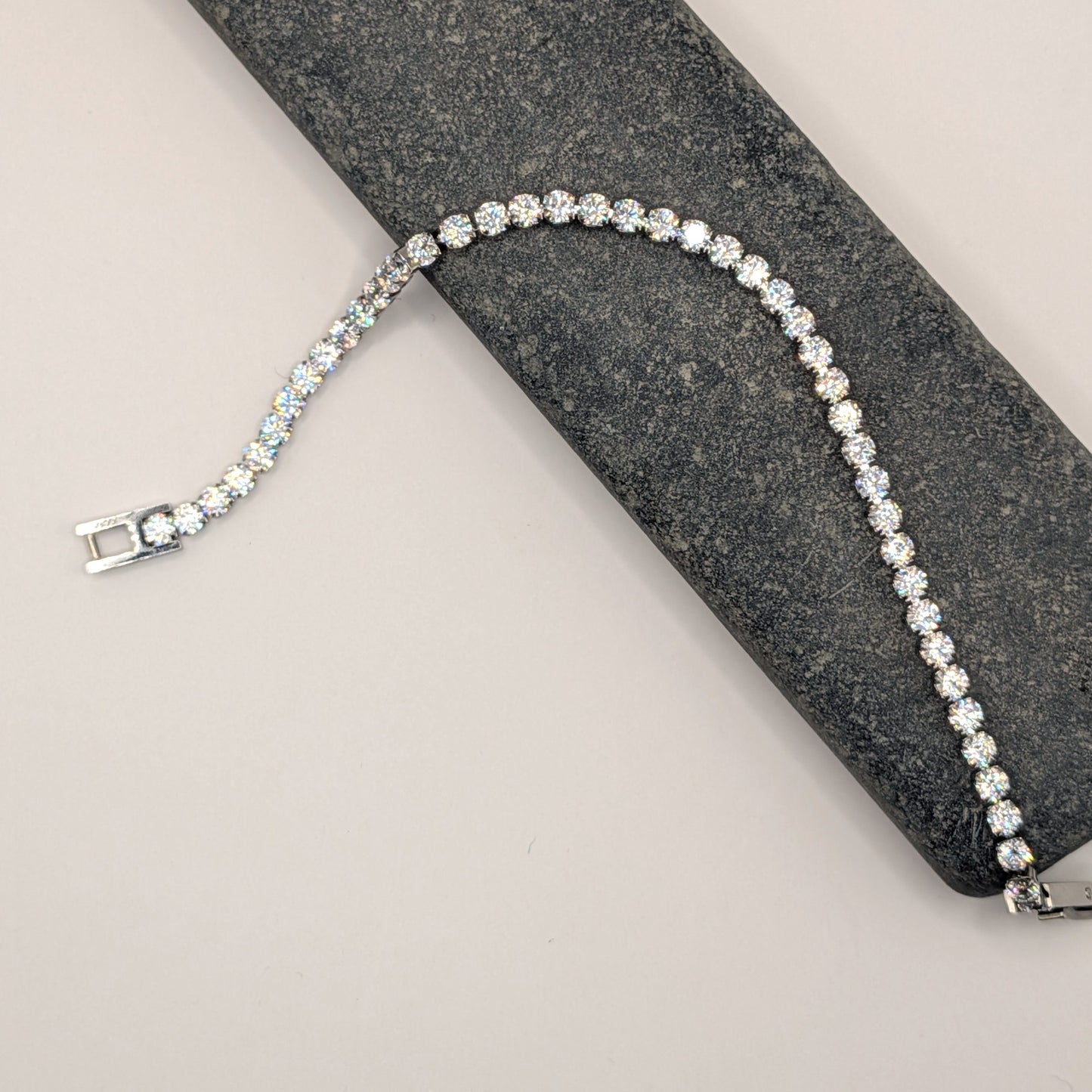 Silver bracelet with clear stones on a gray surface