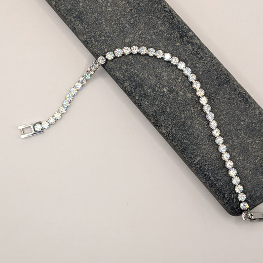 Silver bracelet with clear stones on a gray surface