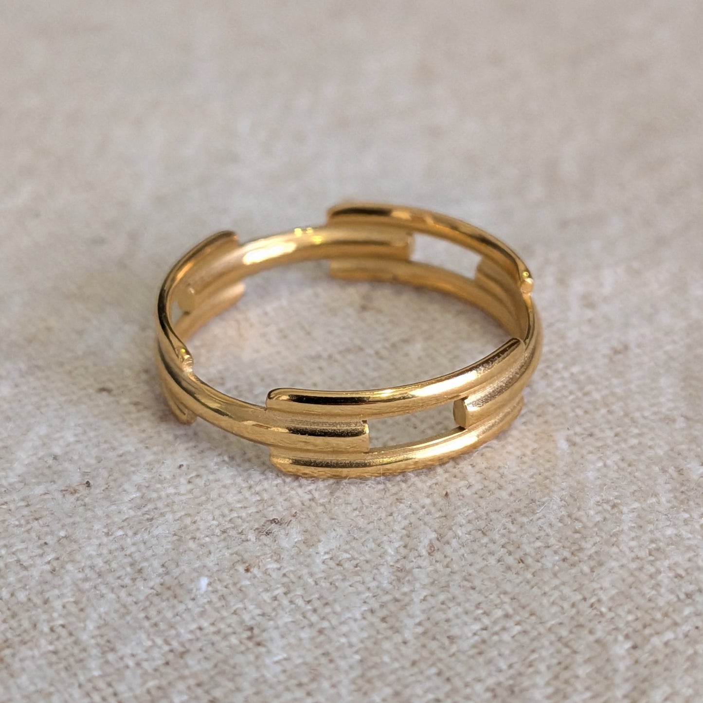 Gold ring on a textured beige surface