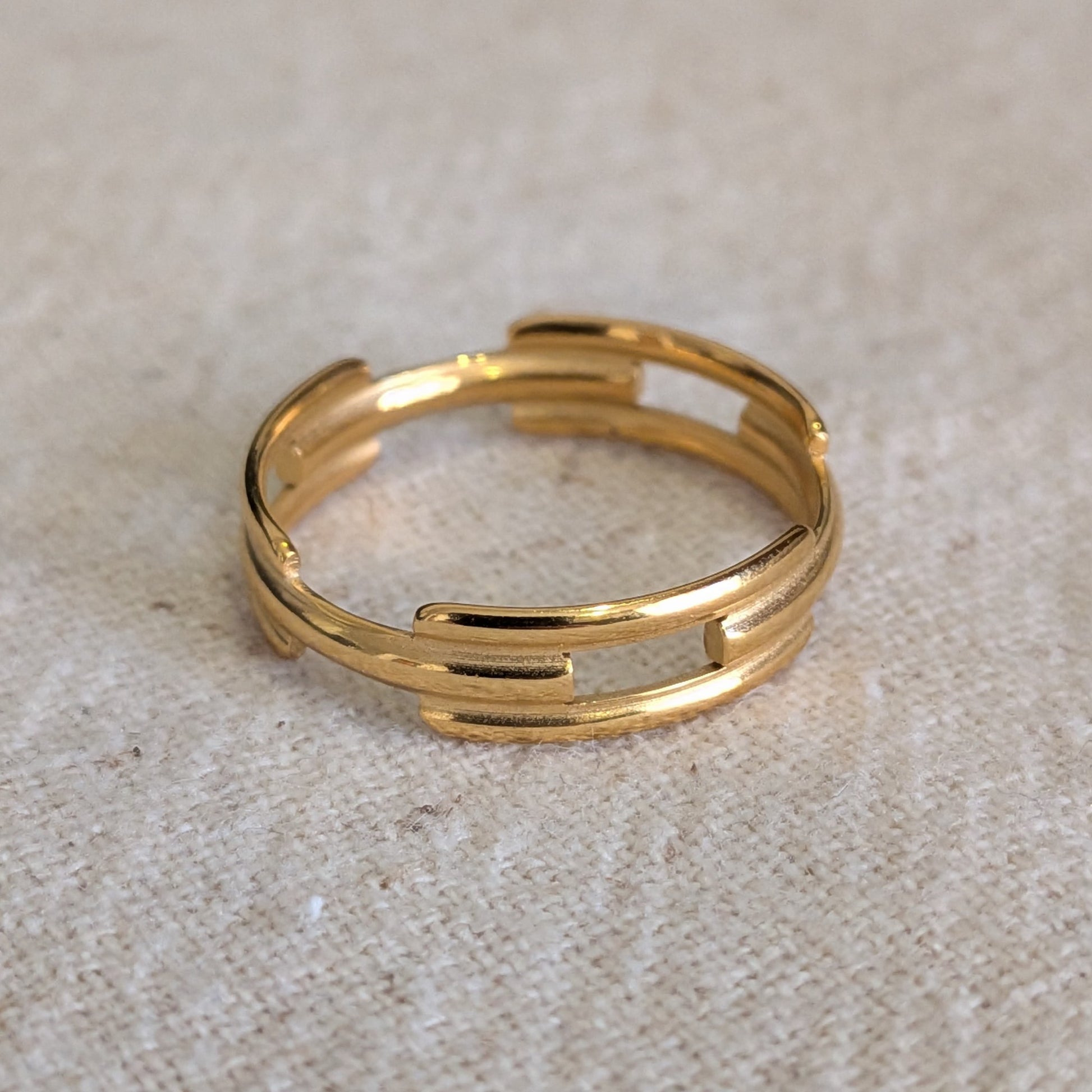 Gold ring on a textured beige surface