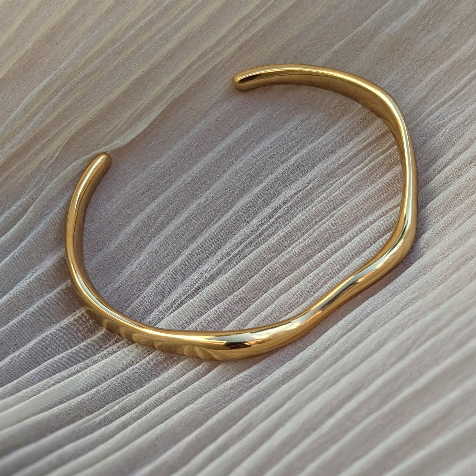 Gold bracelet on a wooden surface